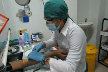A nurse is taking blood to be checked in the hospital laboratory.