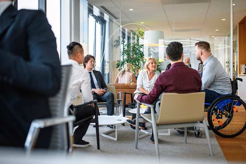 Senior Business Professional Conversing with Male Colleagues