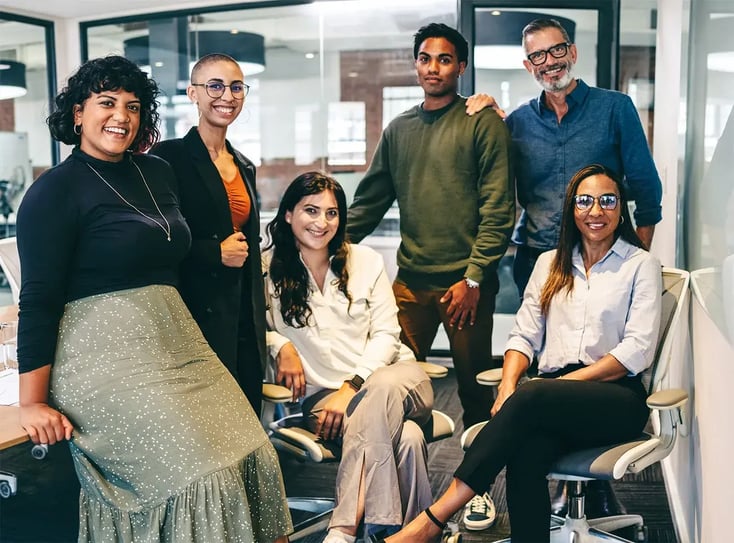Team of businesspeople smiling at the camera in a boardroom