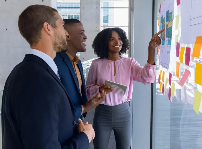 A team maps out priorities on a wall of sticky notes during a planning session.
