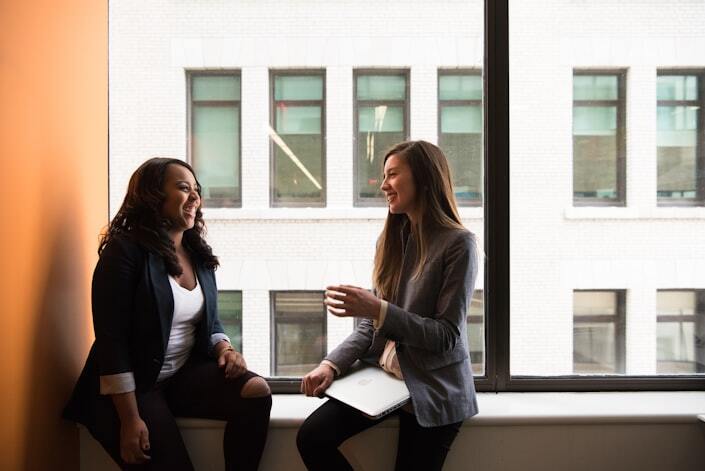 A manager and employee talk during a one-on-one at a small table