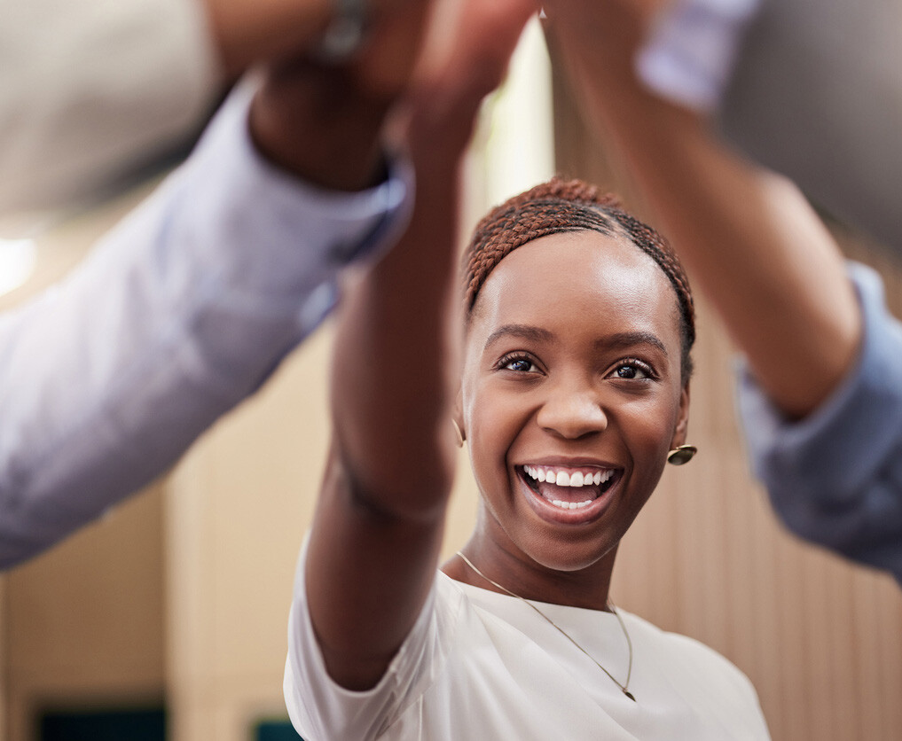 young businesswoman high fiving her work colleagues