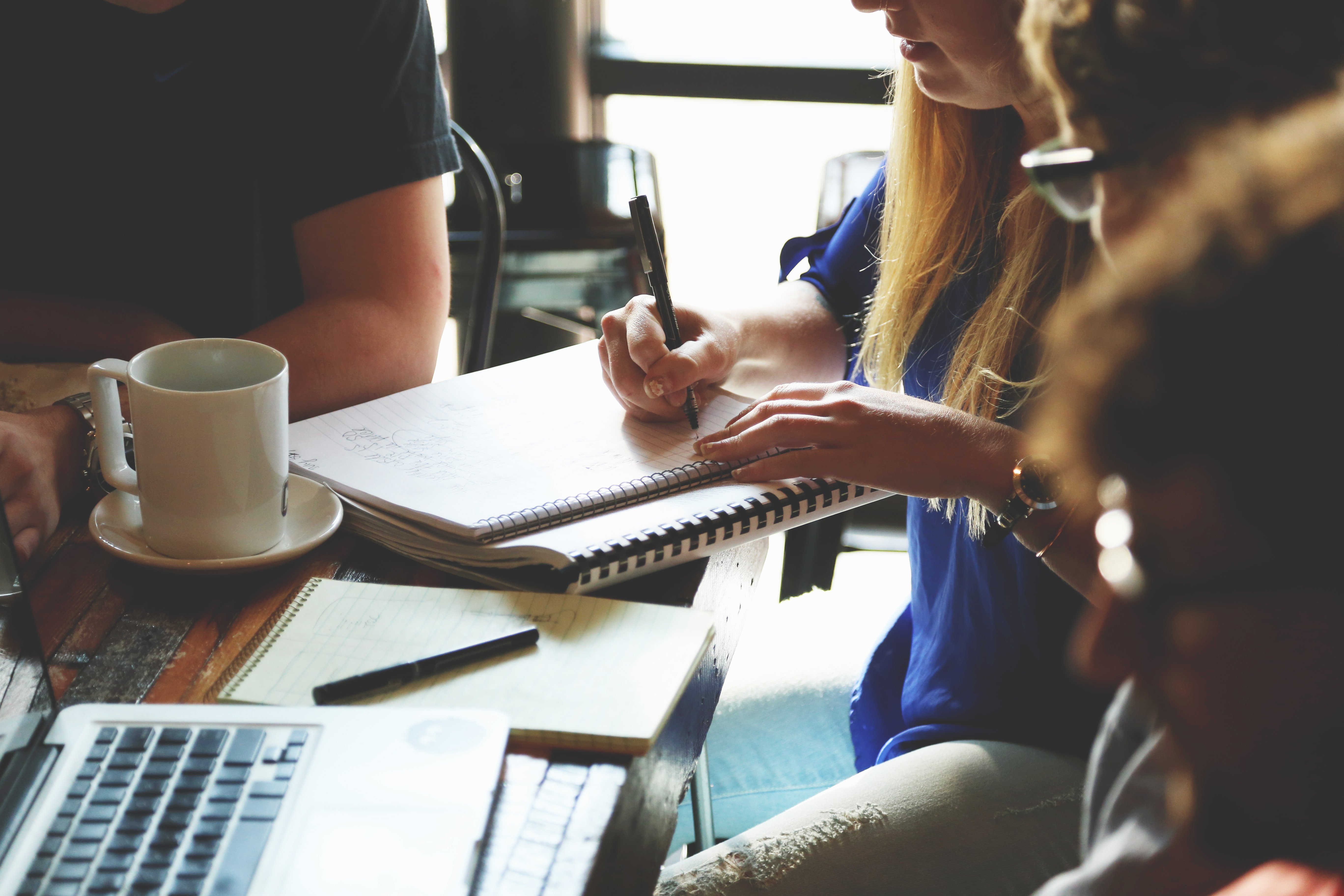 Team members mentoring and collaborating at a table