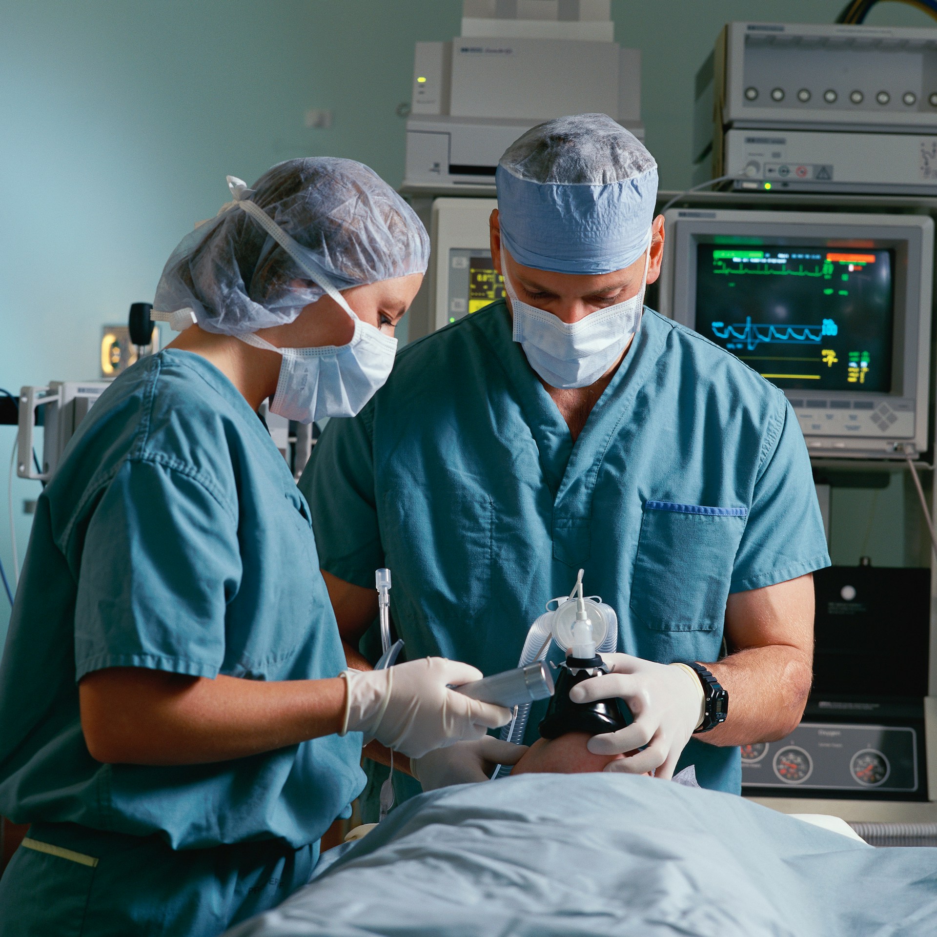 Two anesthesiologists putting patient under