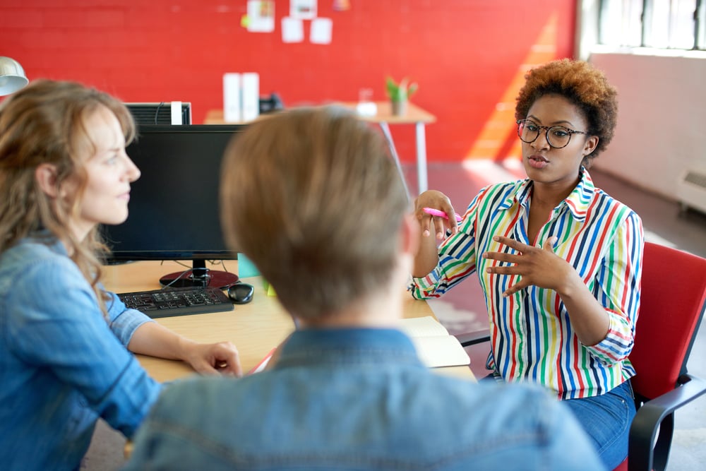 Unposed group of creative business people in an open concept office interviewing