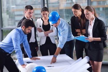 Man in hard hat pointing at construction plans