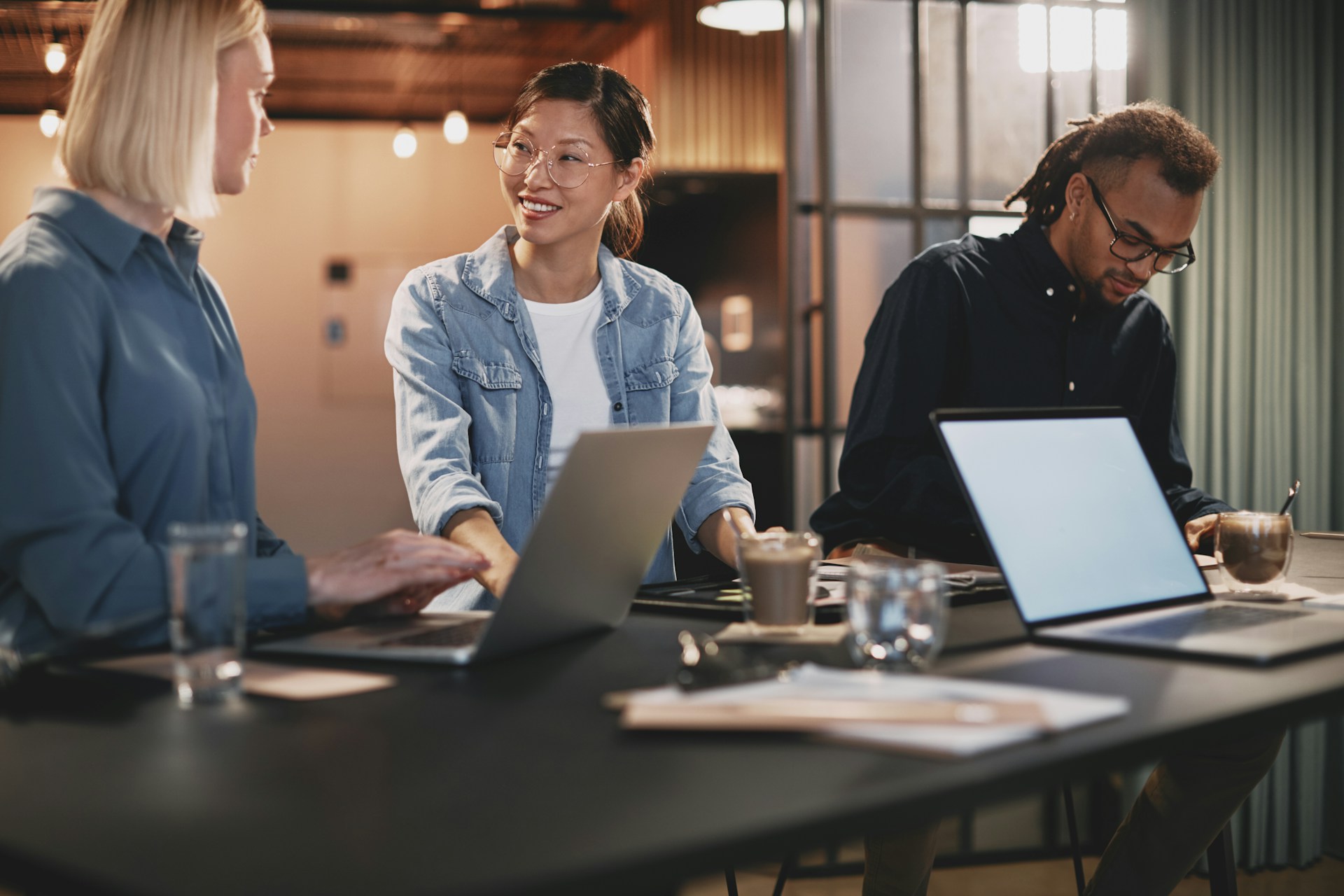 Coworkers at tall desk with laptops