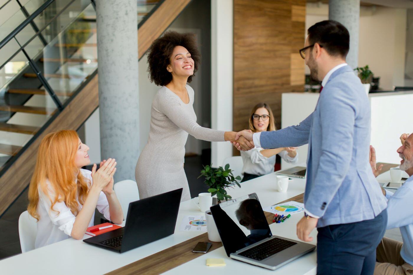 Two colleagues shaking hands after a successful meeting, reflecting a strong working relationship